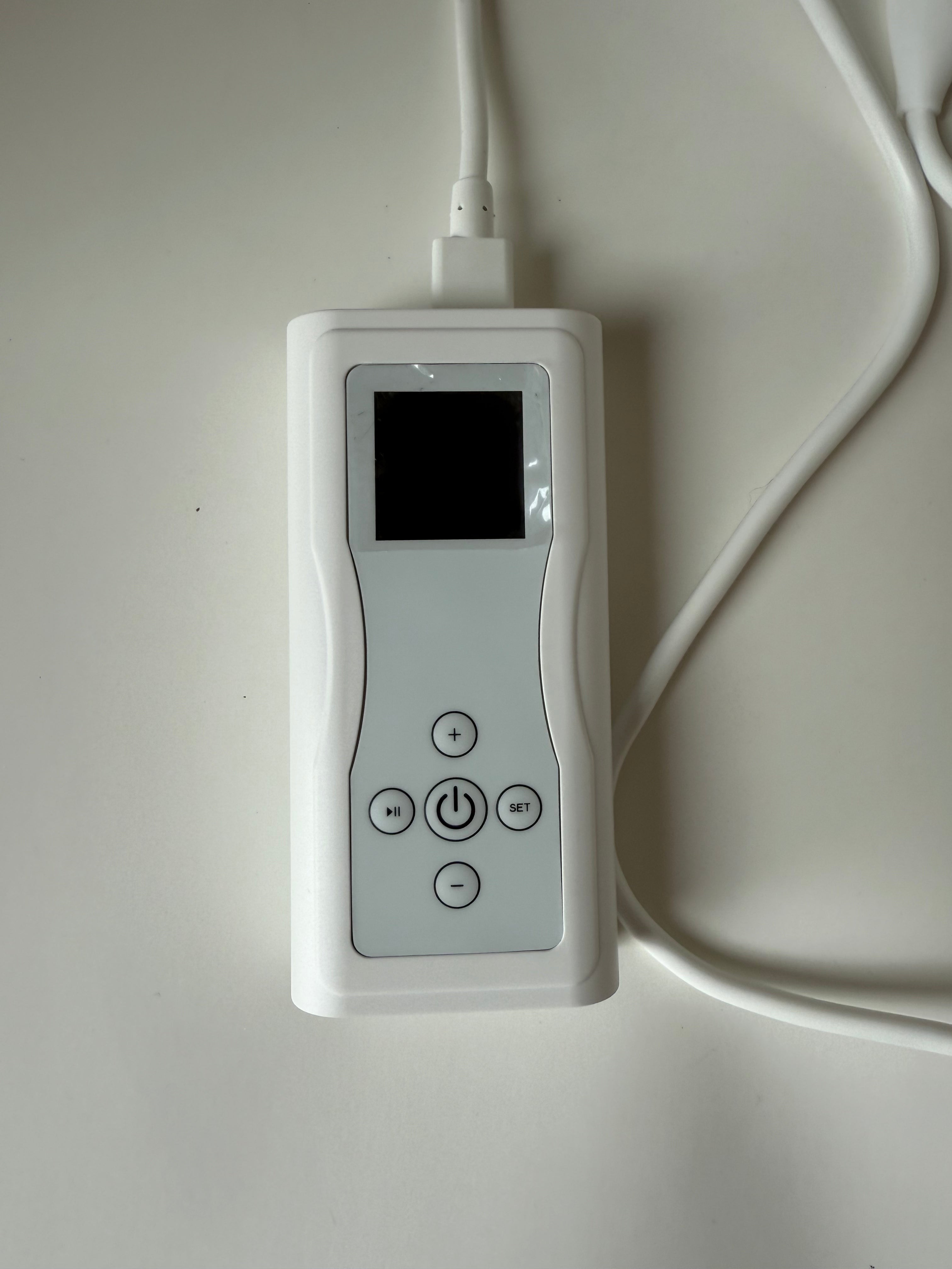 Close-up of red light therapy face mask digital controller showing power and timer settings